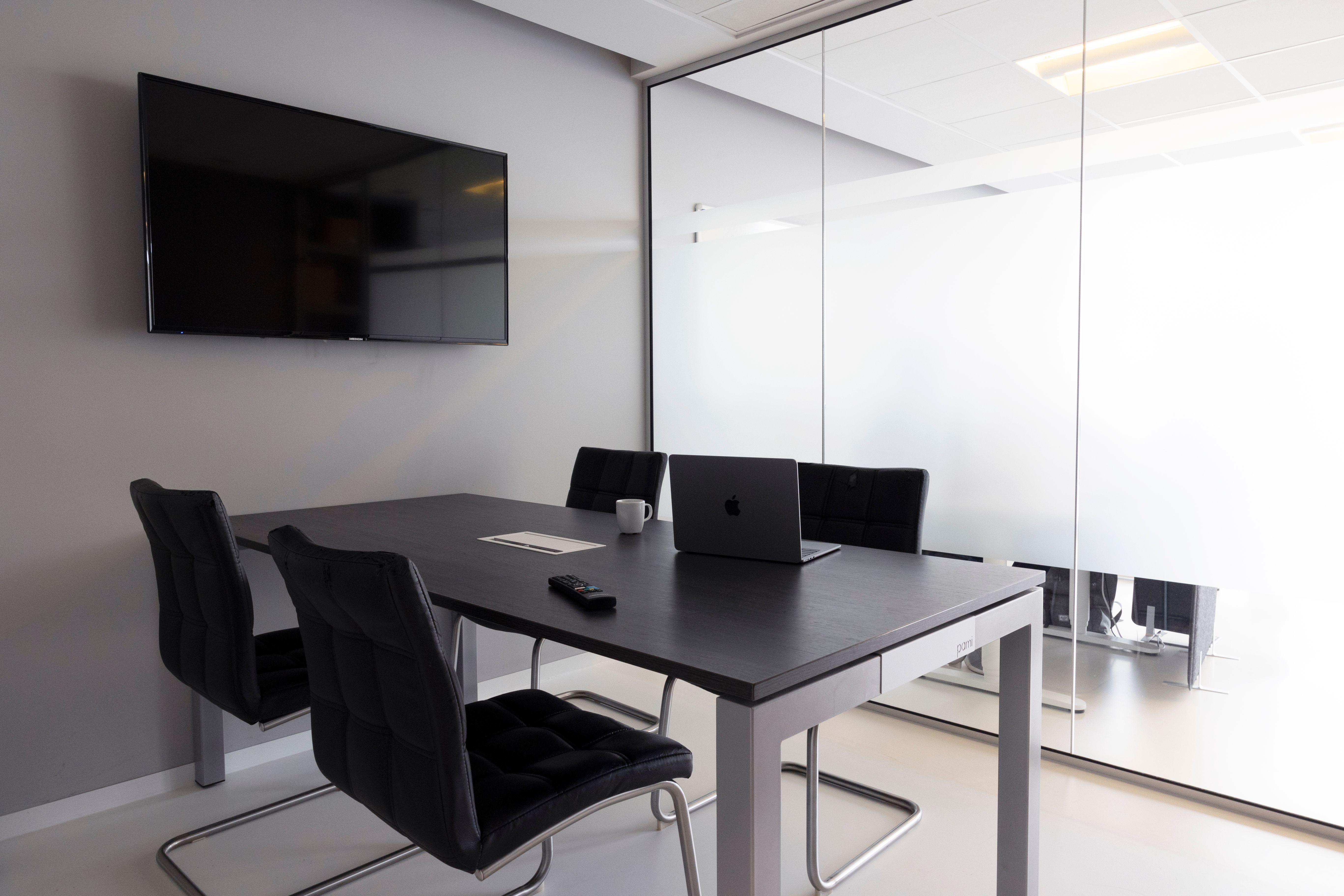 Contemporary glass-walled meeting room with integrated display